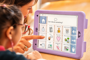 Autistic child using an AAC device with parent